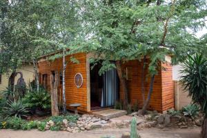 伯诺尼Blyde Africa- Cottage的一个小砖屋,设有门廊和长凳