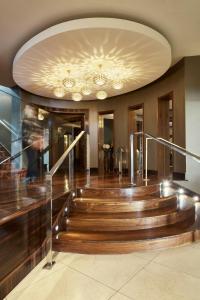 基拉尼基拉尼塔休闲中心酒店的大堂设有木制楼梯和带吊灯的天花板