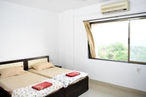 帕纳吉3 BHK Apartment with river view的一间卧室设有两张床和窗户。