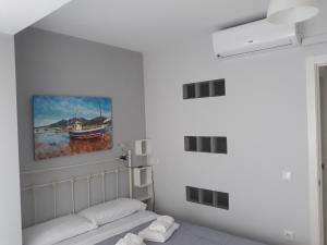 圣波拉Apartamentos Centro的一间设有一张床的客房,墙上挂着一幅画