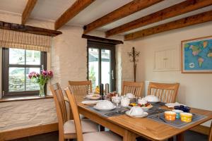 圣提斯The White Cottage B&B的一间带木桌和椅子的用餐室