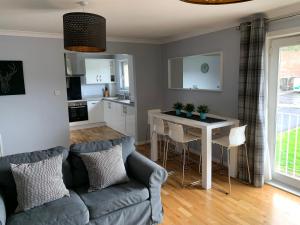 东基尔布赖德Flat Five, 212 Eaglesham Road, East Kilbride, Glasgow的客厅配有沙发和桌子