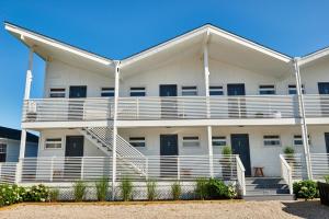 蒙托克英雄海滩俱乐部度假村的公寓大楼设有白色阳台和楼梯。