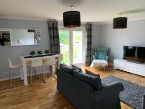 东基尔布赖德Flat Five, 212 Eaglesham Road, East Kilbride, Glasgow的带沙发、桌子和电视的客厅