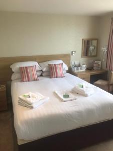 布里德灵顿君主酒店的一间卧室配有一张床,上面有两条毛巾