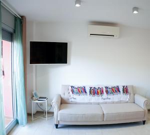 马塔罗Mataro Luxury Apartments的客厅配有白色沙发和平面电视。