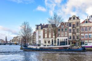 阿姆斯特丹阿姆斯特丹运河酒店的船在建筑物前的河上