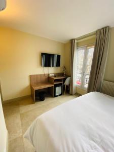 巴黎马莫泰星晨酒店的一间卧室配有一张床和一张书桌及电视