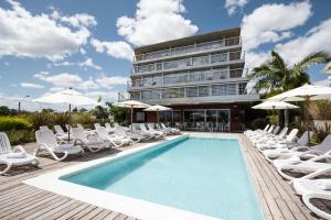 科洛尼亚-德尔萨克拉门托哥斯达科隆尼亚河畔精品酒店的一个带躺椅的游泳池和一间酒店