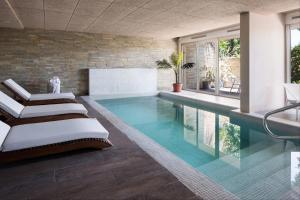 科洛尼亚-德尔萨克拉门托哥斯达科隆尼亚河畔精品酒店的一座房子内带两张躺椅的游泳池