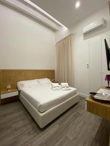 塔兰托Star Suite的卧室配有一张白色大床和一张书桌