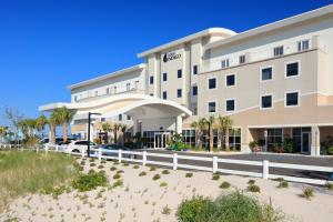 格尔夫海岸Hotel Indigo Orange Beach - Gulf Shores, an IHG Hotel的建筑前有白色围栏的酒店