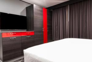 帕萨迪纳帕萨迪纳阿斯特罗酒店的一间带电视和红色橱柜的卧室