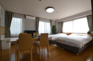 高松Takamatsu - House / Vacation STAY 38164的一间卧室配有一张床、一张桌子和一张桌子