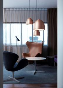 哥本哈根哥本哈根丽笙豪华皇家酒店的配有桌子、椅子和灯具的房间