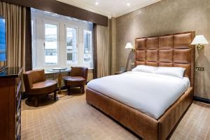 伦敦Radisson Blu Edwardian Hampshire Hotel, London的配有一张床和一张书桌的酒店客房