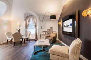 布达佩斯布达佩斯贝克丽笙布鲁酒店的带沙发、电视和桌子的客厅