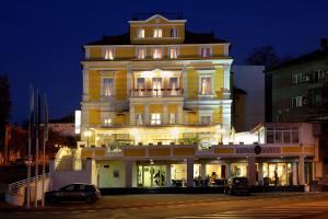 鲁塞安娜宫酒店的一座黄色的大建筑,晚上有灯