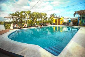 曼努埃尔安东尼奥塞林纳曼努埃尔安东尼奥旅舍的一座拥有蓝色海水和棕榈树的游泳池