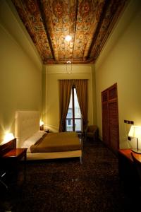 那不勒斯乐德尔精品酒店的一间卧室设有一张床和格子天花板