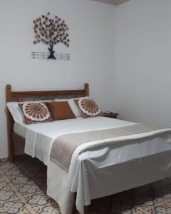 蒂拉登特斯Pousada Mirante Imperial的卧室配有一张床铺,墙上挂着一棵树