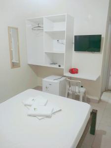 戈亚尼亚戈亚斯酒店的白色的客房配有白色的桌子和椅子