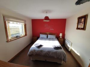 巴里瓦尼奇Taigh nam Piobaireach的一间卧室配有一张红色墙壁的床