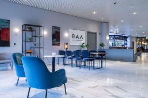 奥胡斯奥尔胡斯蓝色雷迪森北欧酒店的大楼内带蓝色桌椅的大堂