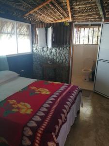 努基Cabañas Refugio Salomon的一间卧室配有一张带红色毯子的床