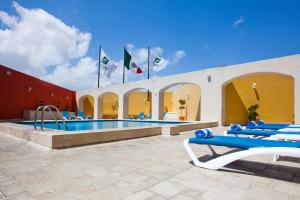 普埃布拉普埃布拉诺里亚假日酒店的一座建筑中带蓝色椅子和旗帜的游泳池