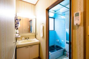 富士吉田市旭阳度假屋的一间带水槽和蓝色淋浴的浴室