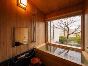 京都100 years old traditional Kyoto Machiya townhouse - K's Villa的带浴缸的浴室和窗户。