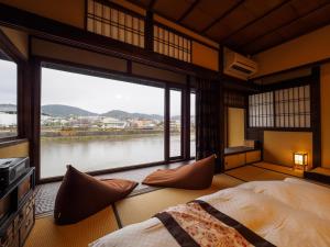 京都100 years old traditional Kyoto Machiya townhouse - K's Villa的卧室设有河景大窗户