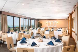 圣地亚哥圣地亚哥湾畔假日酒店的宴会厅配有桌椅和蓝色餐巾