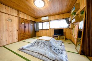 富士吉田市旭阳度假屋的卧室配有一张床铺,位于带木墙的房间内