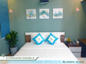 富国FLORA Hotel Phu Quoc的一间卧室配有一张带蓝色和白色枕头的床