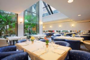 都灵Turin City Centre的餐厅设有桌椅和大窗户。