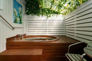 陶波VU Thermal Lodge - ADULTS ONLY MOTEL的木制甲板上的按摩浴缸,