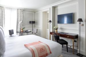 巴黎J.K. Place Paris的酒店客房配有一张床、一张书桌和一台电脑