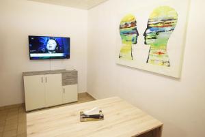 斯图加特Apartment Möhringen的一间设有桌子的房间和墙上的电视