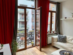 布鲁塞尔Grand Appartement Jourdan EU的客厅设有大窗户和红色窗帘