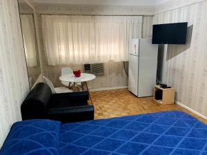 布宜诺斯艾利斯DEPARTAMENTO COCA的客房设有床、桌子和冰箱。