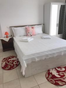 尼普顿Pensiunea Scoika Steaguri Neptun的卧室配有带粉红色枕头的大型白色床