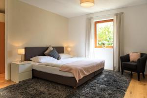 因斯布鲁克Laura´s Smart Apartment的卧室配有床、椅子和窗户。