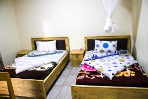 KabarondoAkagera Neighbors的两张睡床彼此相邻,位于一个房间里
