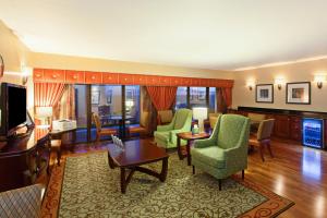 萨克拉门托萨克拉门托市中心区假日酒店的客厅配有沙发、椅子和电视