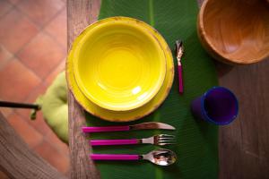 佛罗伦萨Silvia in S.Reparata的桌子上一个黄色的盘子,上面有一些餐具