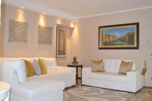 威尼斯SAN MARCO3 Apartment的客厅配有2张白色沙发和一幅画