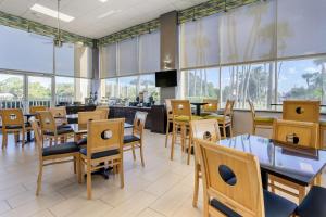 布雷登顿Quality Inn Bradenton North I-75的餐厅设有桌椅和窗户。