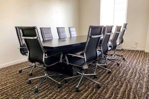 安大略Comfort Inn & Suites Near Ontario Airport的一间会议室,配有一张黑桌子和椅子